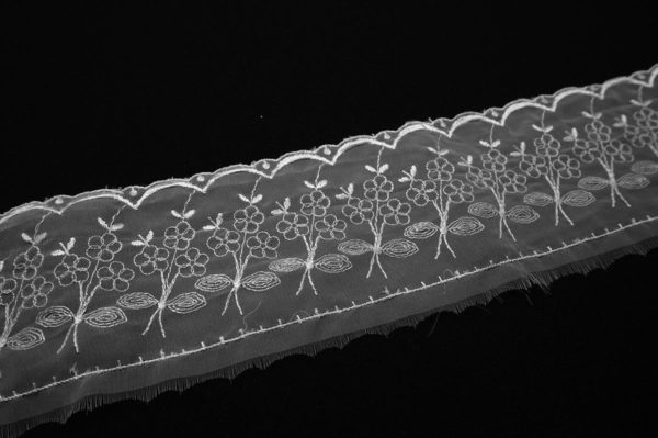 Haft na tkaninie w kolorze białym, szerokość 7 cm